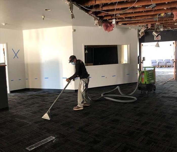 team member using extraction machine to remove water