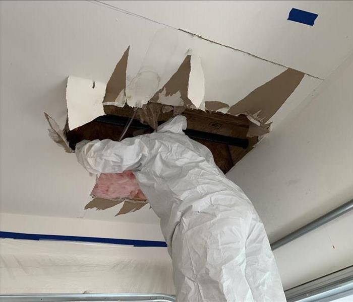 Employee working around a collapsed ceiling.