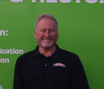 SERVPRO employee in front of green truck